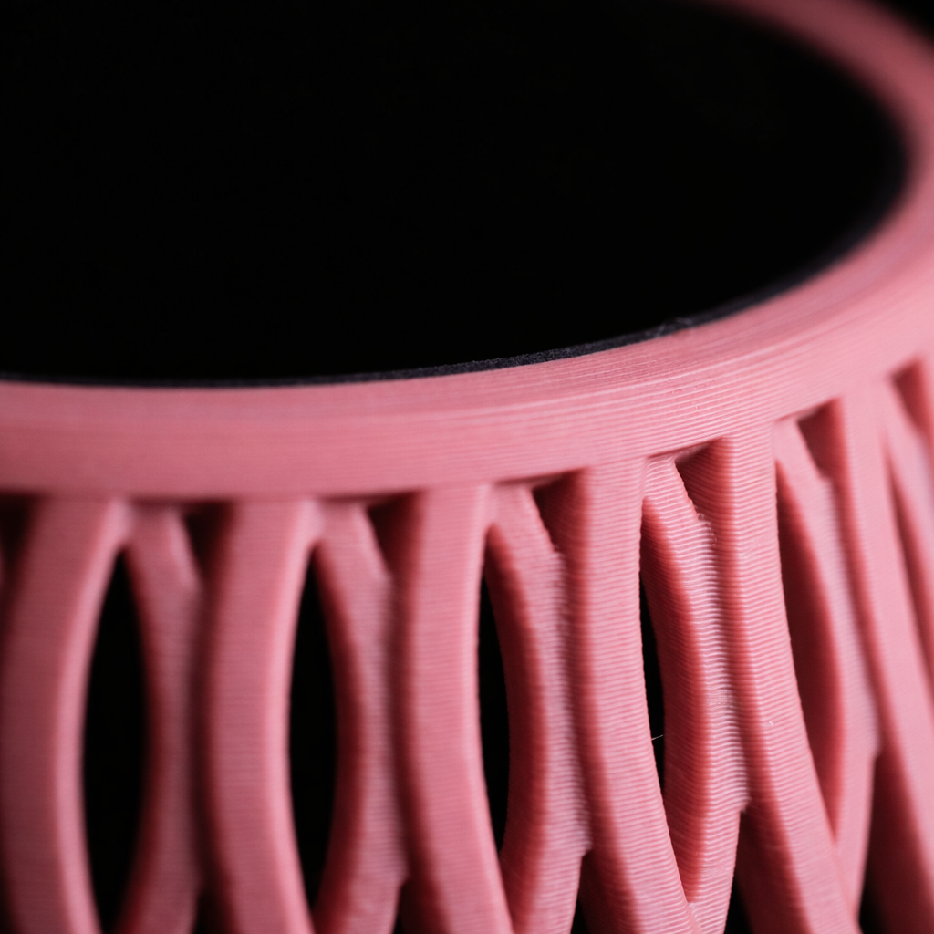 Close-up of a pink 3D-printed object with a black background